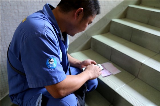 客戶還是沒有到，家具安裝謝師傅蹲在門口等，一邊等一邊處理今天要去的下一家客戶的資料