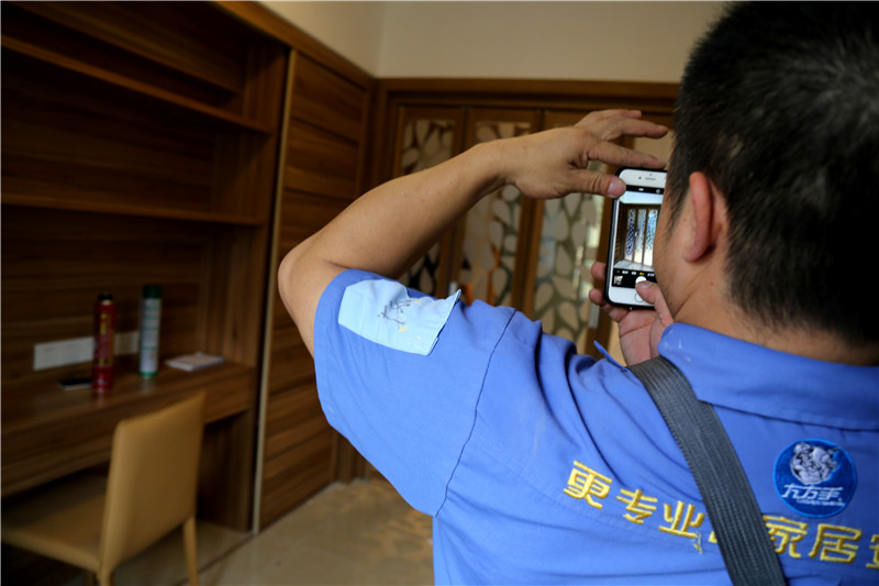 謝師傅看著安裝好的家具，拍下照片
